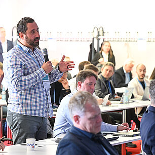 A participant from the audience asks the speaker a question